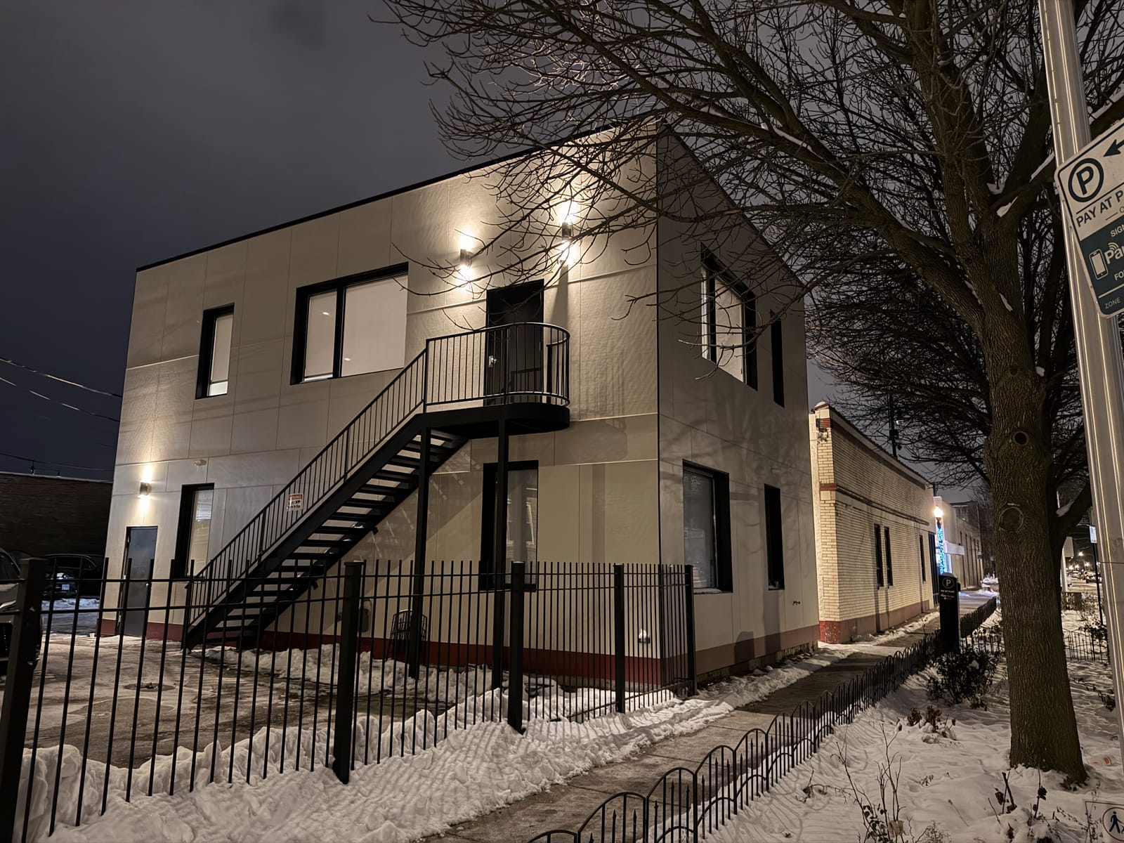 Two-story non-profit organization facility with an exterior steel egress stair in winter